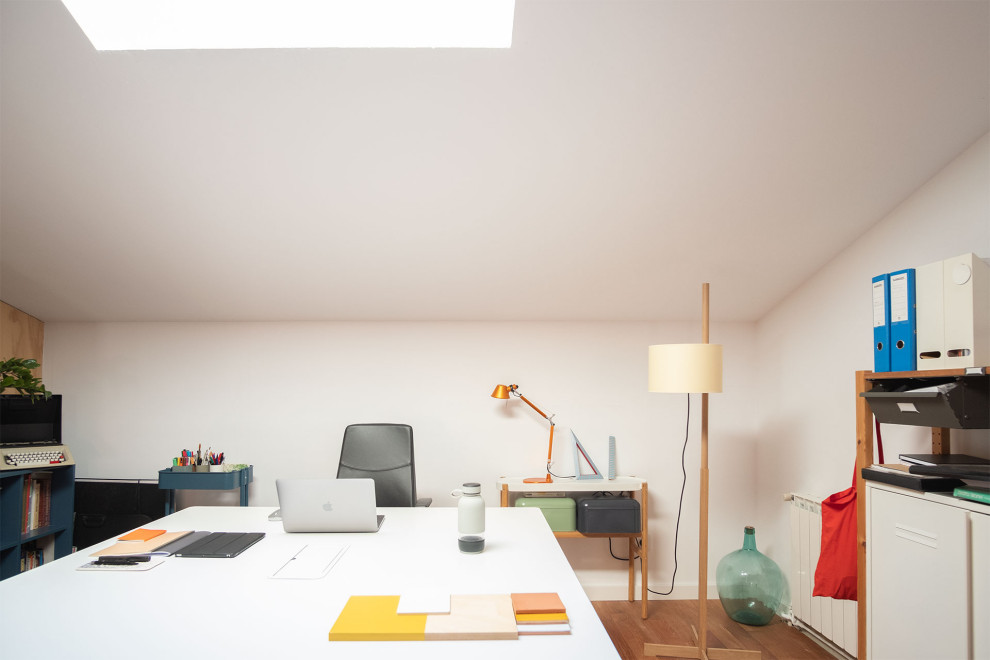 Ejemplo de despacho contemporáneo de tamaño medio con paredes blancas, suelo de madera en tonos medios, escritorio independiente, suelo marrón y madera