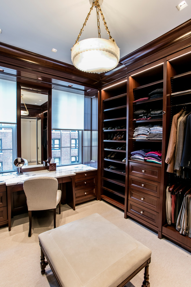 Transitional dressing room in New York with recessed-panel cabinets, dark wood cabinets, carpet and beige floor.