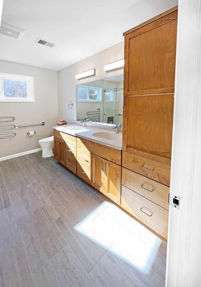 Exempel på ett mellanstort klassiskt beige beige en-suite badrum, med skåp i mellenmörkt trä, ett badkar i en alkov, en kantlös dusch, en toalettstol med hel cisternkåpa, vit kakel, keramikplattor, beige väggar, laminatgolv, ett integrerad handfat, bänkskiva i akrylsten, brunt golv och dusch med skjutdörr