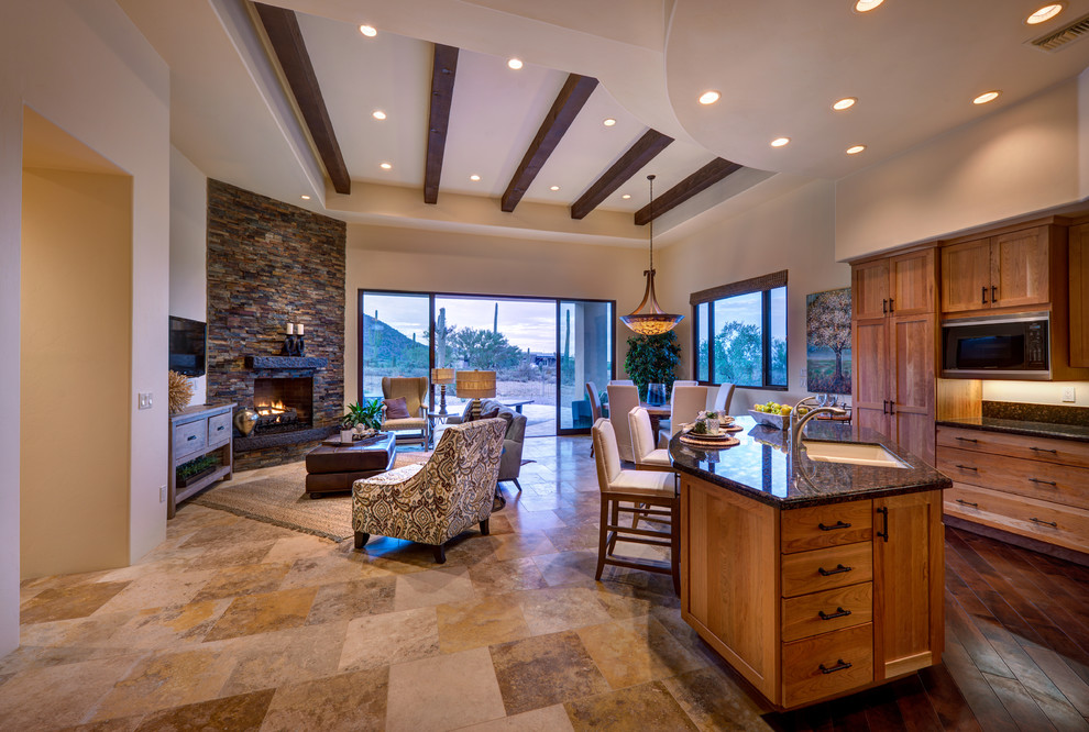 Photo of a large open concept living room in Phoenix with beige walls, a standard fireplace, a stone fireplace surround and a wall-mounted tv.