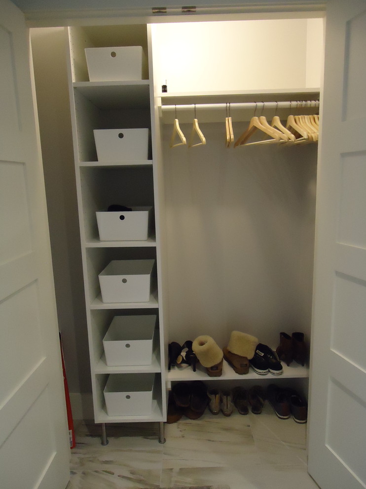 Inspiration for a small contemporary gender-neutral built-in wardrobe in Toronto with porcelain floors.