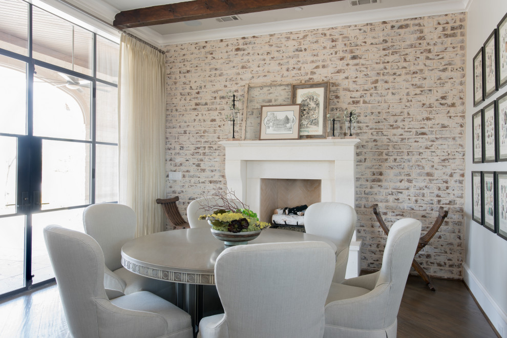 Design ideas for a mid-sized dining room in Dallas with grey walls, dark hardwood floors, a standard fireplace, a stone fireplace surround, brown floor, exposed beam and brick walls.