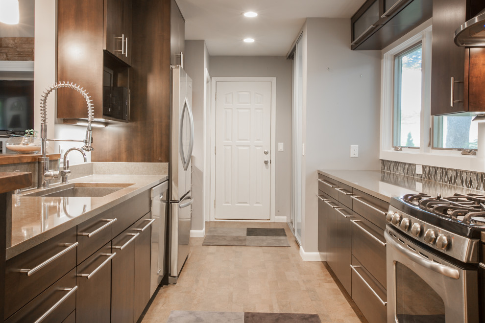 Transitional galley cork floor and gray floor eat-in kitchen photo with an undermount sink, flat-panel cabinets, dark wood cabinets, quartz countertops, mosaic tile backsplash, stainless steel appliances and a peninsula