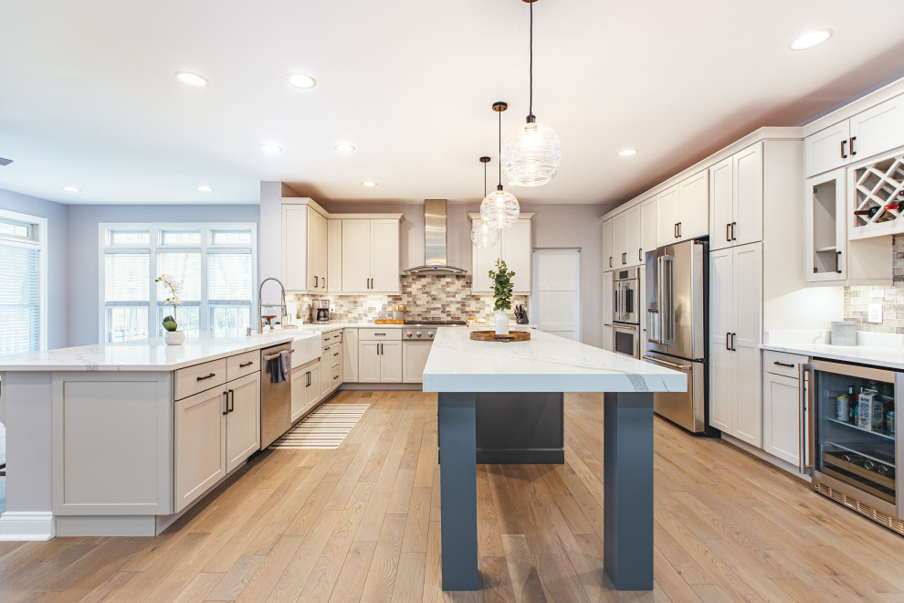 Immagine di una grande cucina design con lavello stile country, ante in stile shaker e pavimento in laminato