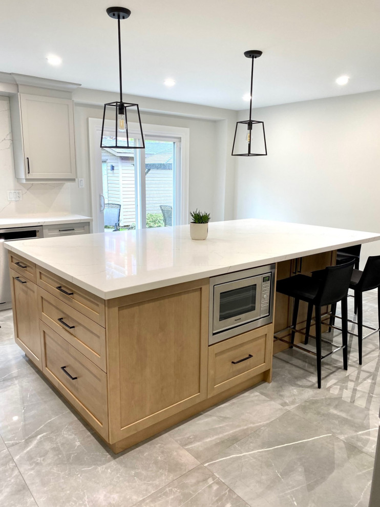 Example of a mid-sized transitional l-shaped porcelain tile open concept kitchen design in Toronto with an undermount sink, shaker cabinets, gray cabinets, quartz countertops, white backsplash, quartz backsplash, stainless steel appliances, an island and white countertops