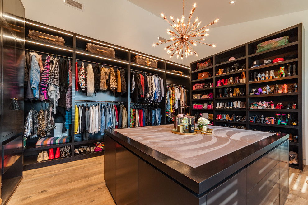 Inspiration for an expansive contemporary women's dressing room in Los Angeles with open cabinets, dark wood cabinets and medium hardwood floors.