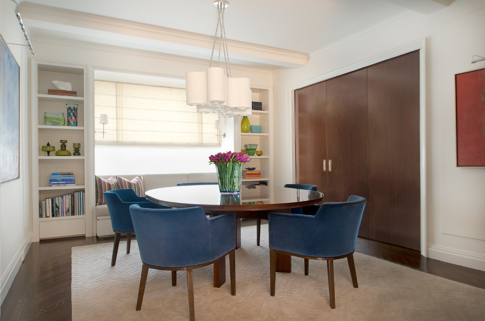 This is an example of a transitional separate dining room in New York with white walls and dark hardwood floors.