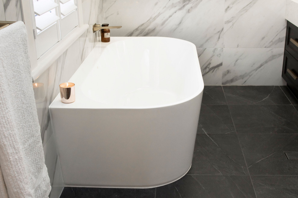 Inspiration for a mid-sized contemporary master bathroom in Adelaide with shaker cabinets, black cabinets, a freestanding tub, a corner shower, a wall-mount toilet, black and white tile, porcelain tile, white walls, porcelain floors, engineered quartz benchtops, grey floor, a hinged shower door, white benchtops, a double vanity and a floating vanity.