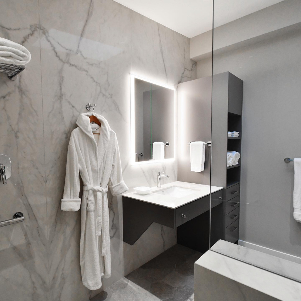 Exempel på ett mellanstort modernt vit vitt en-suite badrum, med släta luckor, vita skåp, en kantlös dusch, en bidé, grå kakel, mosaik, ett undermonterad handfat, granitbänkskiva, med dusch som är öppen, grå väggar, laminatgolv och grått golv