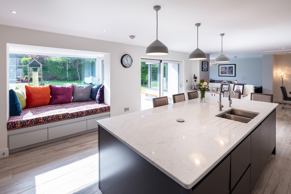 Inspiration for a mid-sized modern l-shaped open plan kitchen in Other with an integrated sink, flat-panel cabinets, grey cabinets, marble benchtops, white splashback, marble splashback, stainless steel appliances, porcelain floors, with island, grey floor and white benchtop.