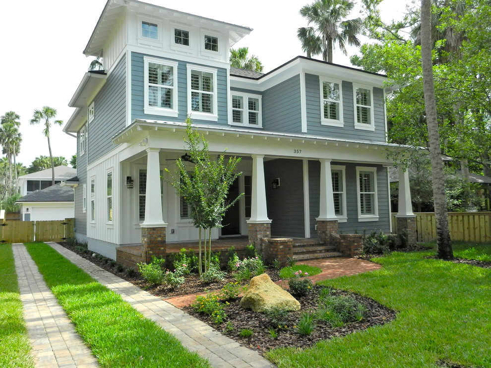 Photo of a large arts and crafts three-storey grey house exterior in Jacksonville with wood siding, a hip roof and a shingle roof.