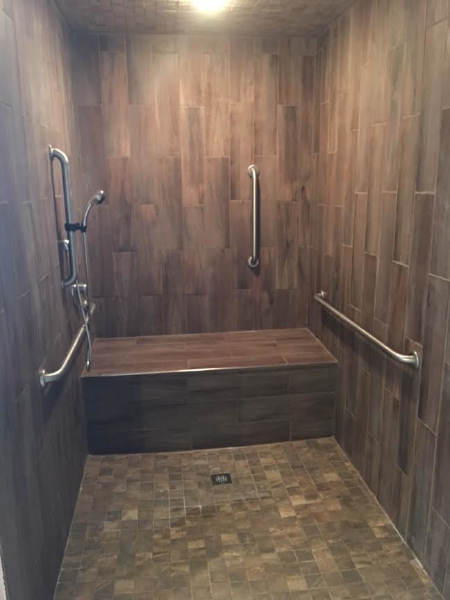Example of a transitional brown tile and porcelain tile alcove shower design