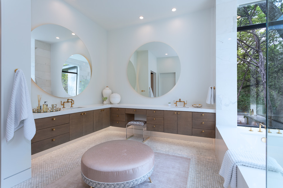 This is an example of a contemporary master bathroom in Austin with flat-panel cabinets, medium wood cabinets, an undermount tub, white walls, mosaic tile floors, an undermount sink, white floor and white benchtops.