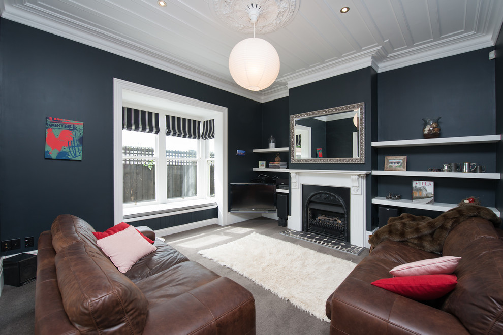 This is an example of a contemporary enclosed living room in Christchurch with blue walls, carpet, a standard fireplace, a plaster fireplace surround and a wall-mounted tv.