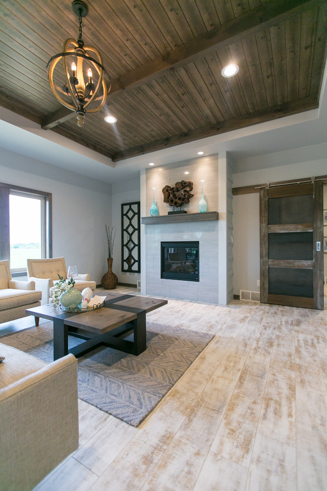 Photo of a large country formal open concept living room in Other with white walls, a standard fireplace, a tile fireplace surround and laminate floors.