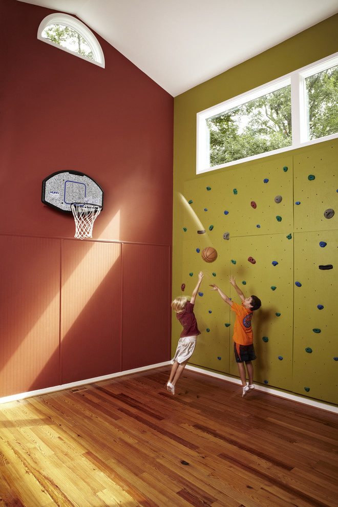 This is an example of a mid-sized transitional home climbing wall in DC Metro with red walls, medium hardwood floors and brown floor.