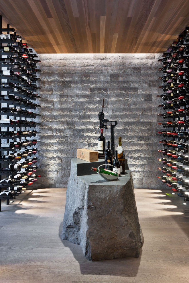 Inspiration for a large country wine cellar in Madrid with medium hardwood floors, storage racks and beige floor.