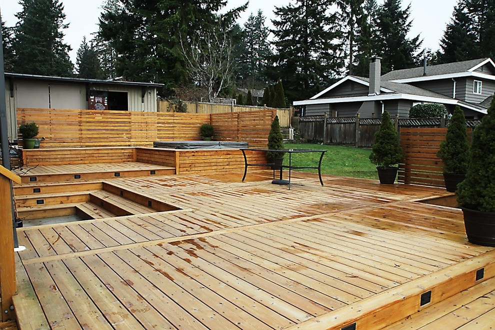 Example of a large mountain style backyard water fountain deck design in Vancouver with no cover