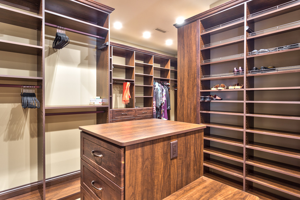 Walk-in closet - large rustic gender-neutral medium tone wood floor and brown floor walk-in closet idea with recessed-panel cabinets and brown cabinets