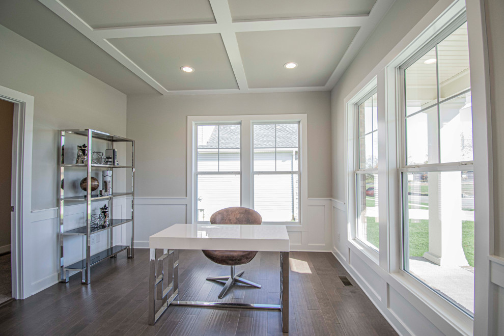 Photo of a mid-sized transitional study room in Louisville with grey walls, medium hardwood floors, a freestanding desk and brown floor.