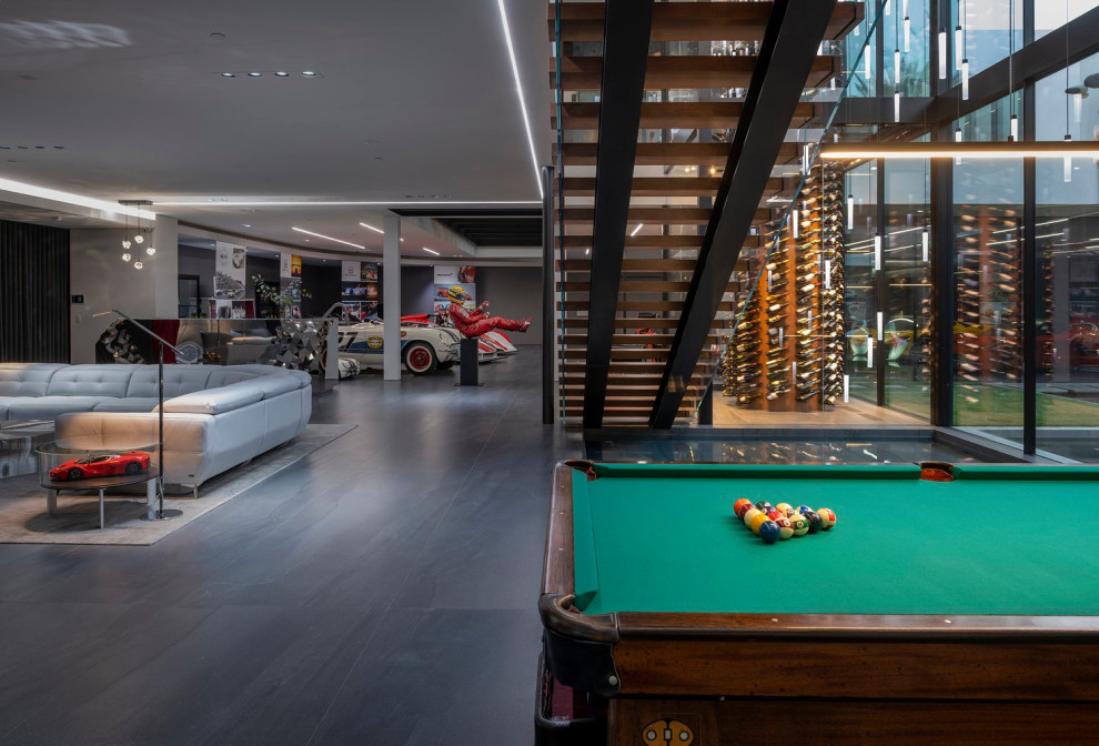 Photo of an expansive modern loft-style family room in Los Angeles with a game room, white walls, porcelain floors, grey floor and recessed.