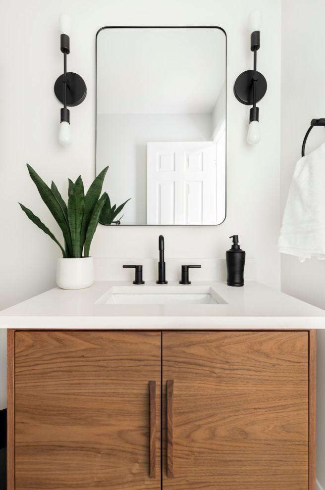 Aménagement d'une salle d'eau rétro en bois clair avec un lavabo encastré, un plan de toilette en quartz modifié, un plan de toilette blanc, meuble simple vasque et meuble-lavabo sur pied.