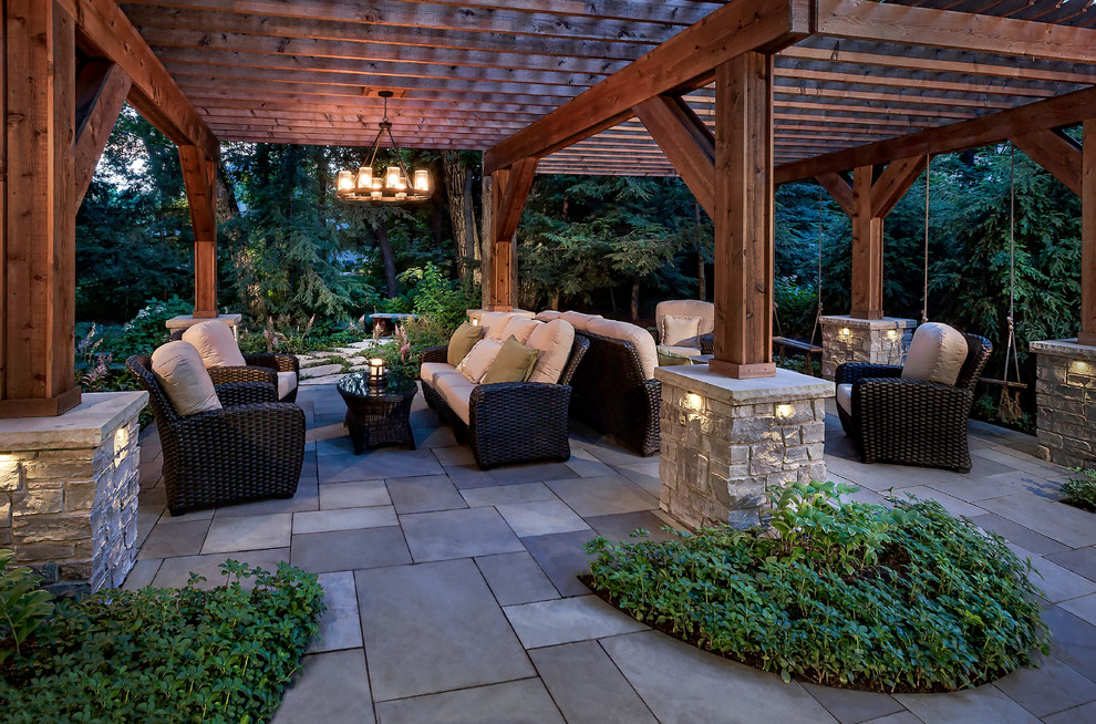 This is an example of a mid-sized contemporary backyard patio in Chicago with natural stone pavers.