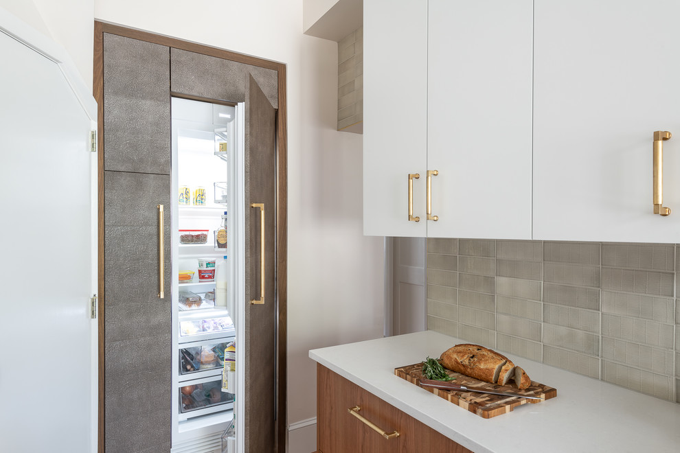 Inspiration for a mid-sized midcentury galley kitchen pantry in DC Metro with an undermount sink, flat-panel cabinets, medium wood cabinets, quartzite benchtops, white splashback, porcelain splashback, stainless steel appliances, medium hardwood floors, no island, brown floor and white benchtop.