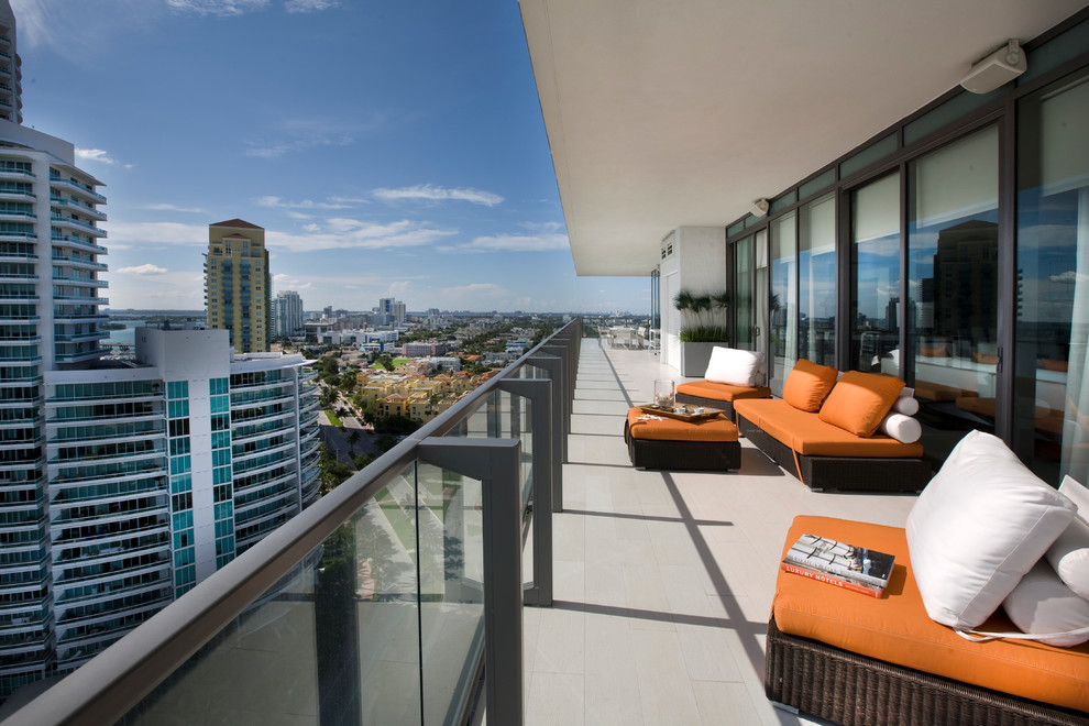 Photo of a contemporary balcony in Miami with a roof extension.