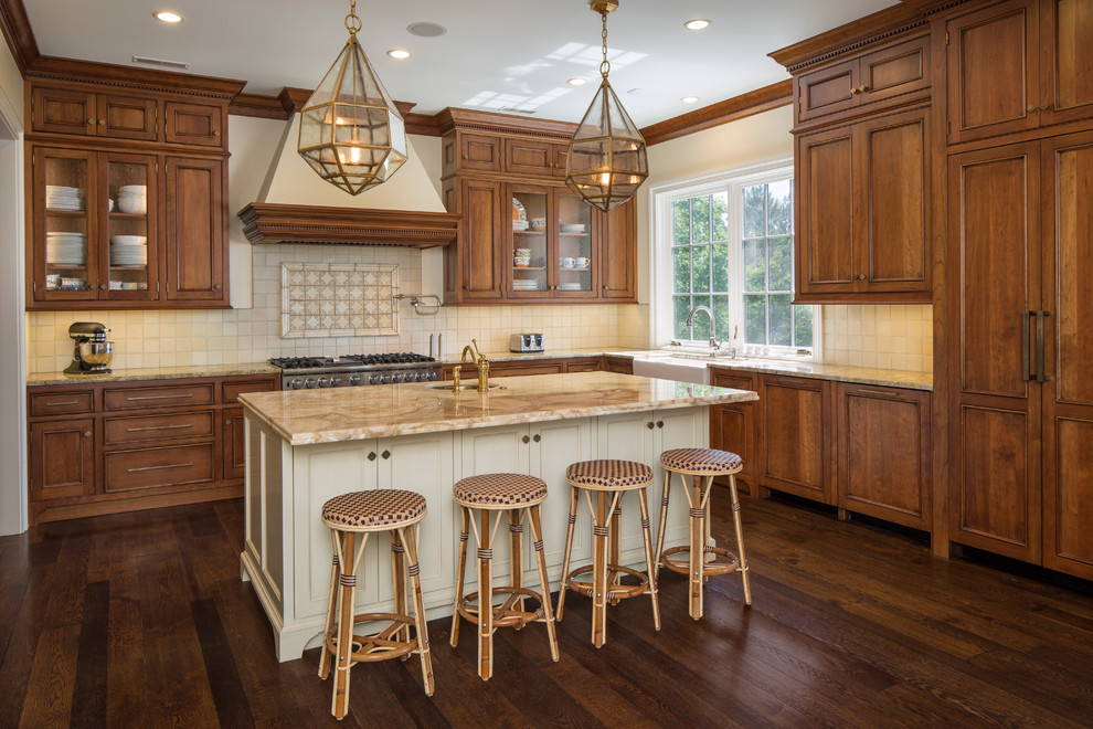 This is an example of a traditional kitchen in Cincinnati with a farmhouse sink, beaded inset cabinets, medium wood cabinets, beige splashback, stainless steel appliances, medium hardwood floors and with island.