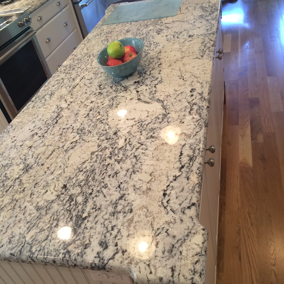 Transitional u-shaped medium tone wood floor eat-in kitchen photo in Boston with an undermount sink, raised-panel cabinets, white cabinets, granite countertops, blue backsplash, glass tile backsplash, stainless steel appliances and an island