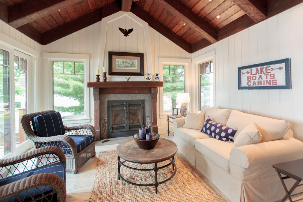 Photo of a country family room in Minneapolis with white walls, a standard fireplace and beige floor.