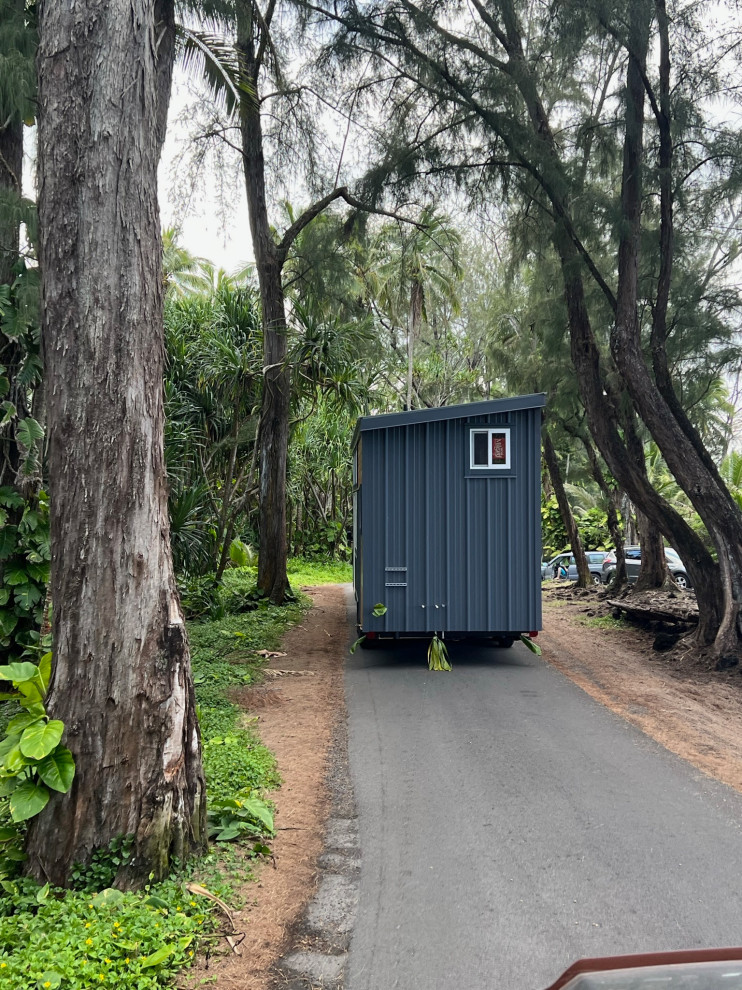 Photo of a small and gey contemporary two floor tiny house in Hawaii with metal cladding, a lean-to roof, a metal roof and a grey roof.