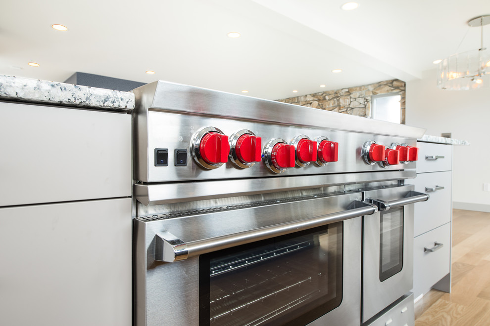 Inspiration for a large transitional u-shaped light wood floor and beige floor open concept kitchen remodel in Seattle with an undermount sink, flat-panel cabinets, dark wood cabinets, granite countertops, gray backsplash, matchstick tile backsplash, stainless steel appliances, an island and multicolored countertops