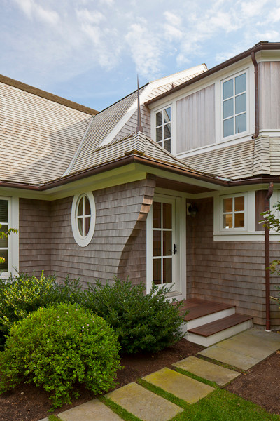 Photo of an expansive beach style two-storey grey house exterior in Boston with wood siding, a gambrel roof and a shingle roof.