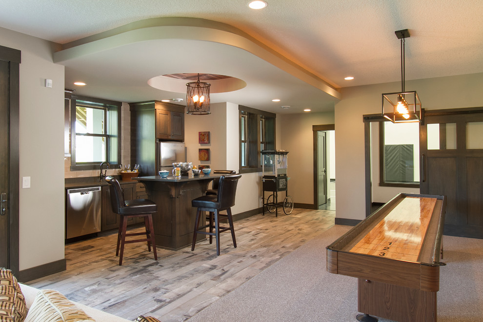 Inspiration for a large transitional single-wall seated home bar in Minneapolis with an undermount sink, shaker cabinets, dark wood cabinets, solid surface benchtops, beige splashback, subway tile splashback and medium hardwood floors.