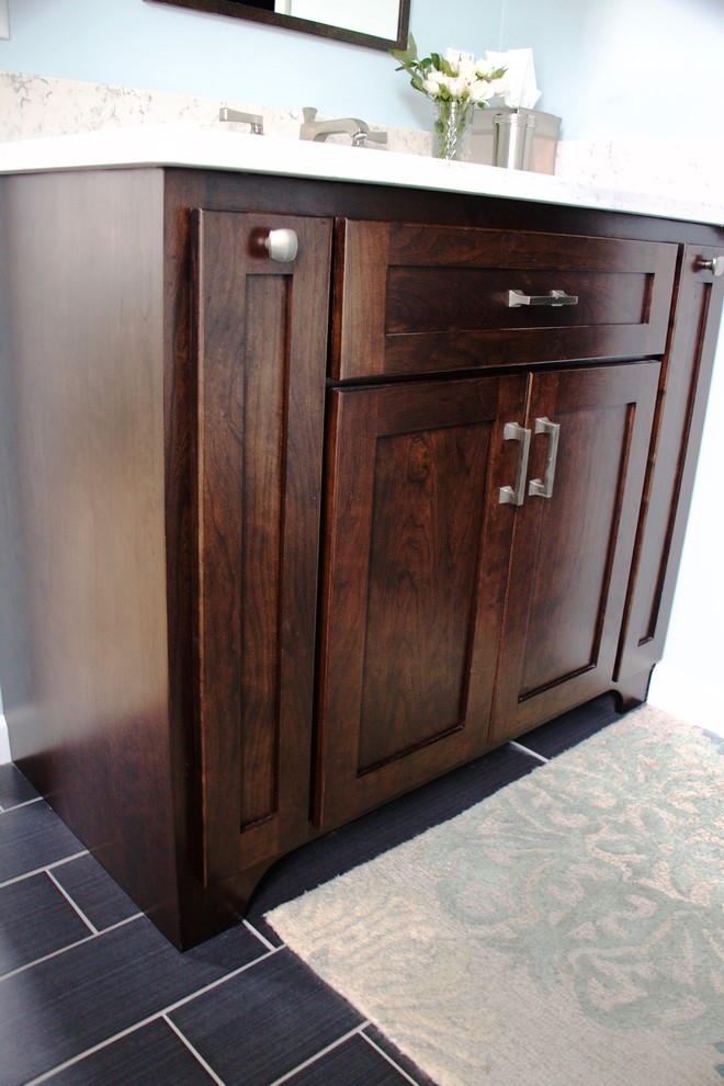 Small transitional master white tile and ceramic tile ceramic tile corner shower photo with shaker cabinets, dark wood cabinets, a two-piece toilet, blue walls, an undermount sink and quartz countertops