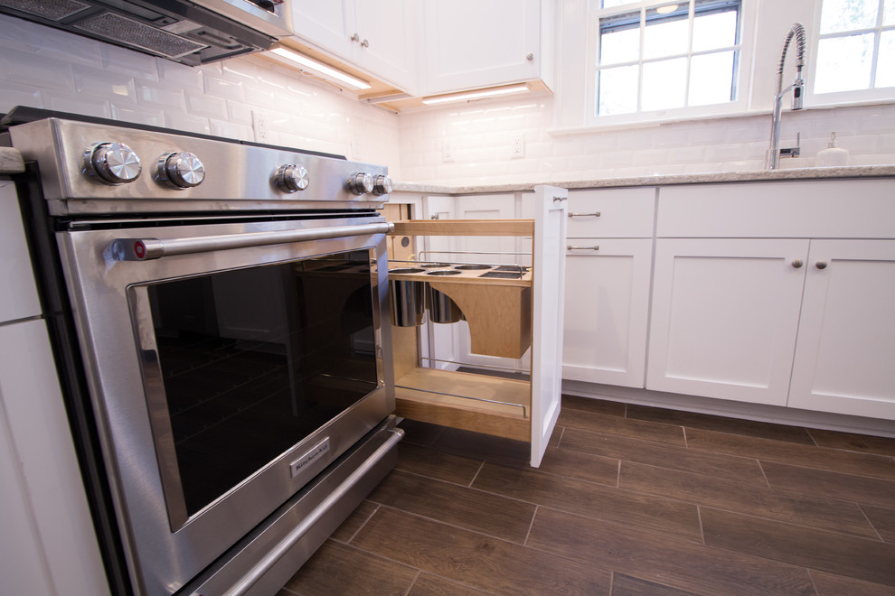 Eat-in kitchen - small u-shaped ceramic tile eat-in kitchen idea with an undermount sink, shaker cabinets, white cabinets, quartz countertops, white backsplash, subway tile backsplash, stainless steel appliances, an island and white countertops