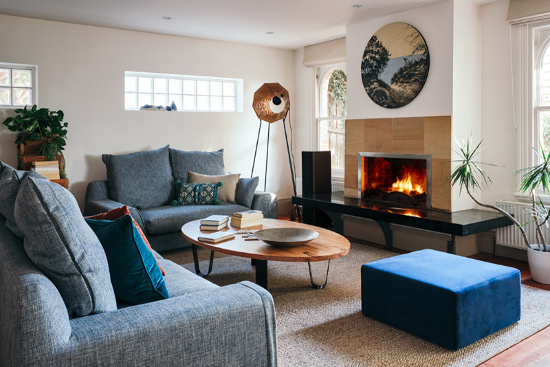 This is an example of a mid-sized contemporary open concept living room in Melbourne with white walls, medium hardwood floors, a standard fireplace, a stone fireplace surround and brown floor.