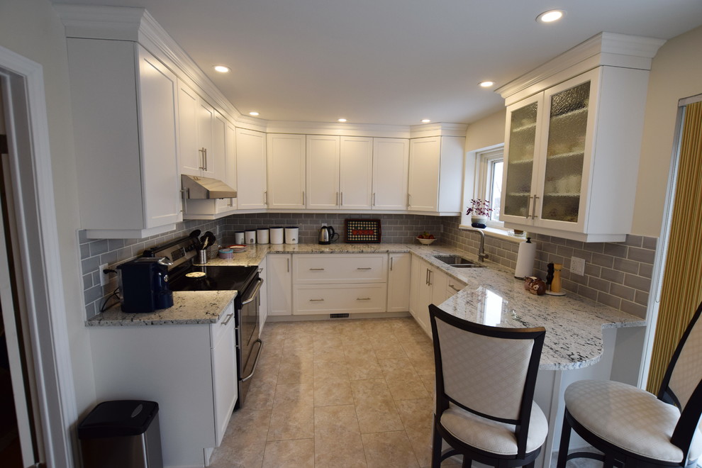 Mid-sized transitional u-shaped ceramic tile enclosed kitchen photo in Ottawa with an undermount sink, shaker cabinets, white cabinets, granite countertops, gray backsplash, glass tile backsplash, stainless steel appliances and a peninsula