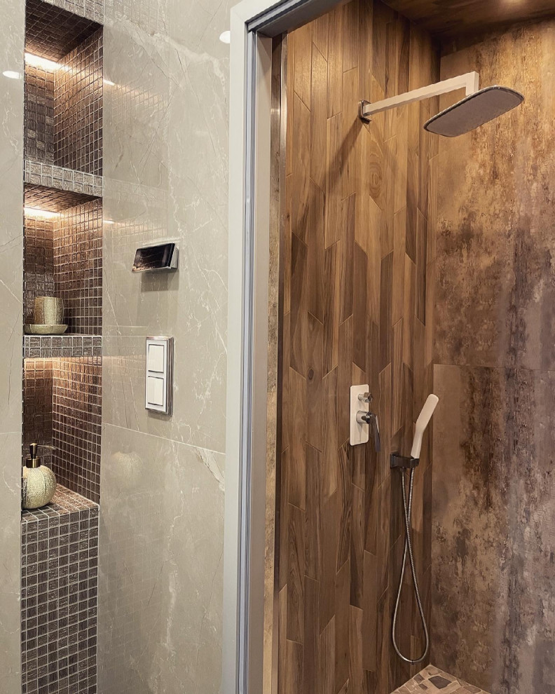 Bild på ett mellanstort funkis badrum, med släta luckor, skåp i mellenmörkt trä, våtrum, brun kakel, porslinskakel, bruna väggar, klinkergolv i porslin, ett integrerad handfat, grått golv och dusch med gångjärnsdörr