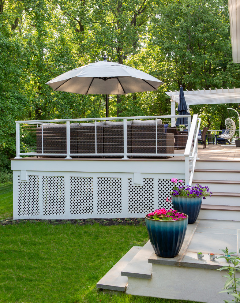 This is an example of a large modern back ground level wire cable railing terrace in Philadelphia with a fire feature and a pergola.