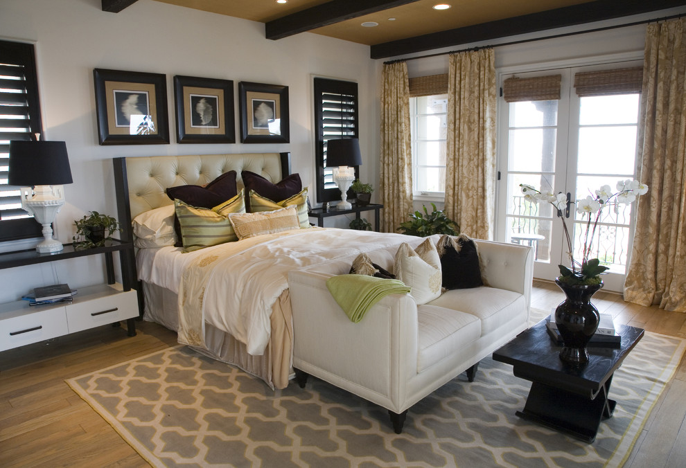 Photo of a large transitional guest bedroom in San Diego with white walls and light hardwood floors.