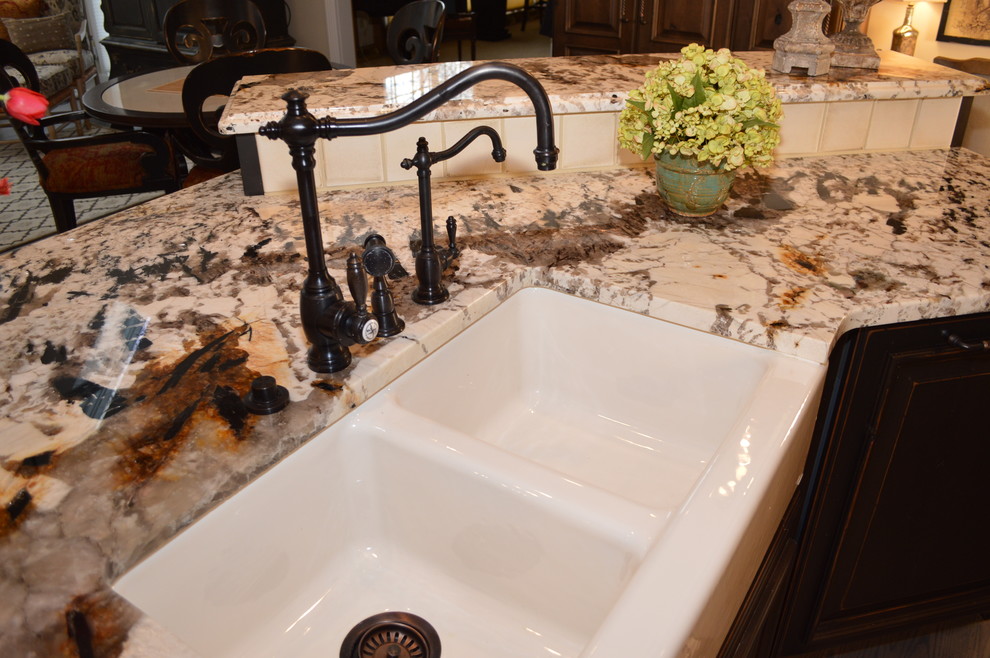 Eat-in kitchen - large traditional l-shaped medium tone wood floor eat-in kitchen idea in Cleveland with a farmhouse sink, light wood cabinets, granite countertops, paneled appliances and an island