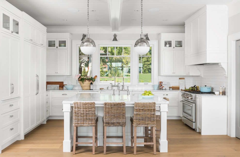 Mid-sized transitional u-shaped light wood floor, beige floor and shiplap ceiling eat-in kitchen photo with an undermount sink, shaker cabinets, white cabinets, quartz countertops, white backsplash, subway tile backsplash, paneled appliances, an island and white countertops