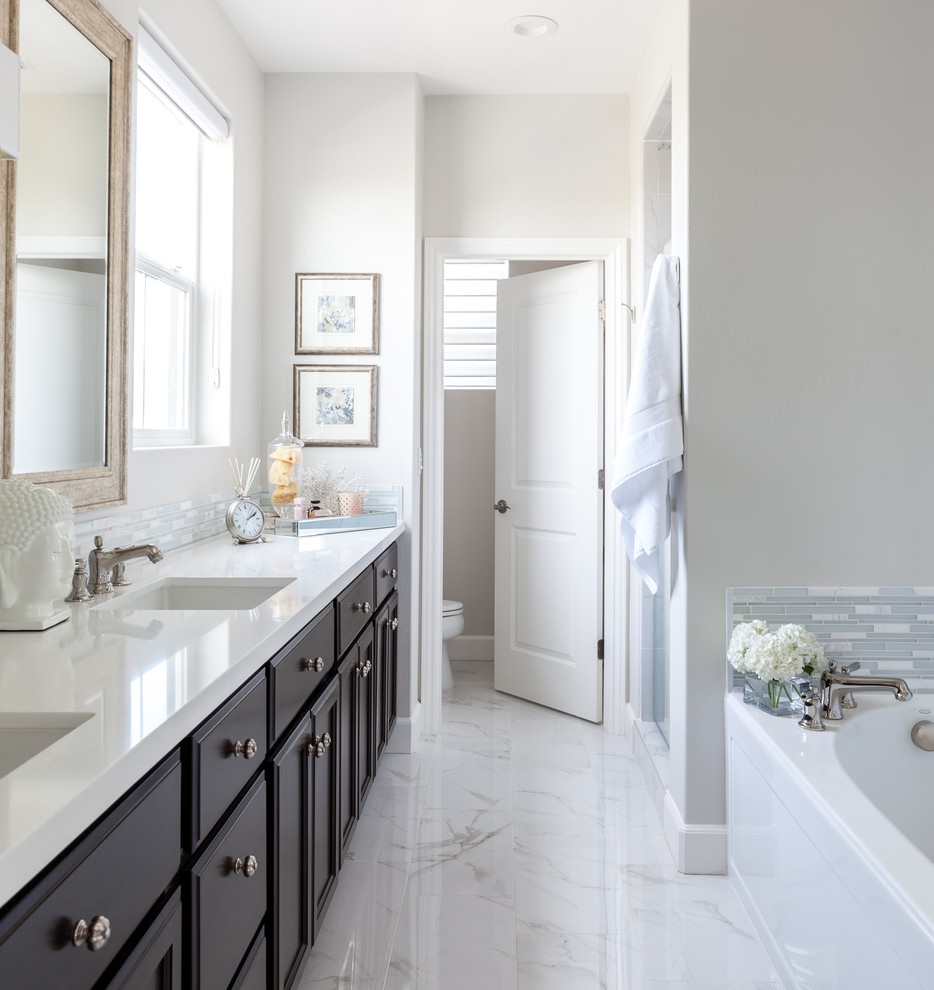 Design ideas for a mid-sized transitional master bathroom in Sacramento with recessed-panel cabinets, dark wood cabinets, an alcove tub, an alcove shower, a two-piece toilet, white tile, matchstick tile, grey walls, porcelain floors, an undermount sink and engineered quartz benchtops.
