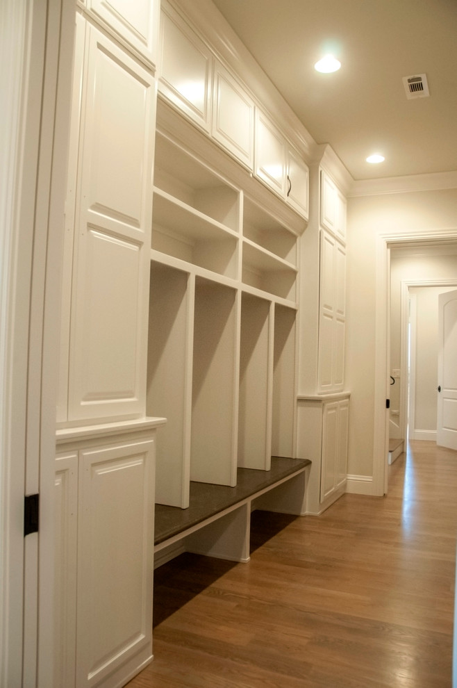 Example of a large transitional medium tone wood floor mudroom design with beige walls