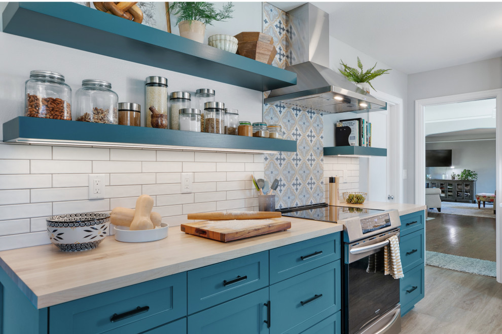 This is an example of a mid-sized eclectic galley separate kitchen in Portland with a drop-in sink, shaker cabinets, turquoise cabinets, quartz benchtops, multi-coloured splashback, porcelain splashback, stainless steel appliances, vinyl floors, no island, beige floor and white benchtop.