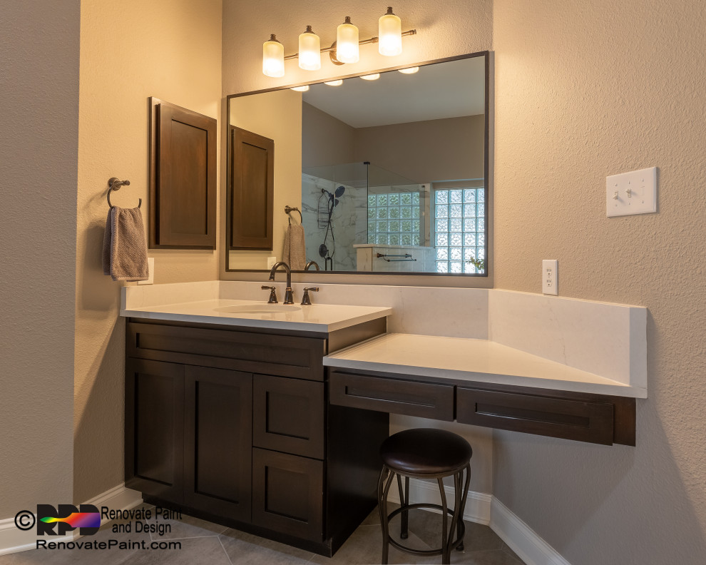 Photo of a large contemporary ensuite bathroom in Austin with shaker cabinets, dark wood cabinets, a freestanding bath, a corner shower, a one-piece toilet, white tiles, ceramic tiles, beige walls, ceramic flooring, a submerged sink, quartz worktops, grey floors, a hinged door, white worktops, a shower bench, double sinks and a freestanding vanity unit.