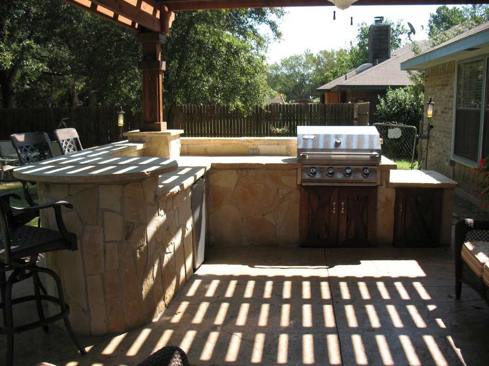 Photo of a mid-sized traditional backyard patio in Dallas with stamped concrete and a pergola.
